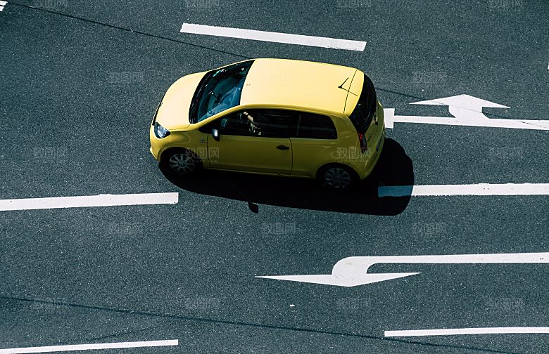 行驶在沥青公路上的黄色汽车图片