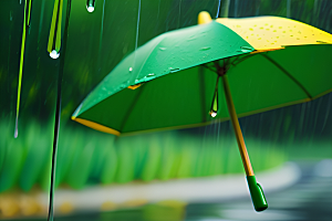 绿色背景下的水滴与黄色雨伞