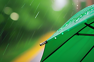 绿色背景中的雨滴与黄色雨伞
