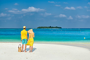 穿着黄色衣服的夫妇热带海滩上马尔代夫的暑
