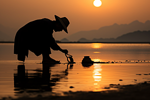 海边赶海落日礁石摄影图