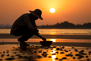 海边赶海夕阳滩涂摄影图