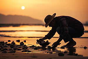 海边赶海黎明落日摄影图